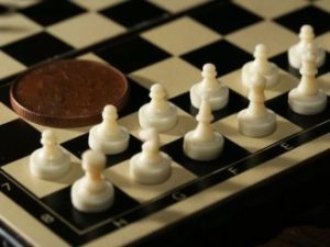 7548-close-up-of-a-miniature-chess-set-with-a-coin-pv-326x245-3464209